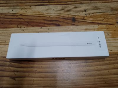 Une Apple Watch est posée dans une boîte sur une table en bois