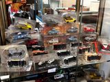 many different types of toy cars on display in a glass case