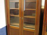 un meuble en bois avec des portes en verre dans le coin d'une pièce