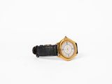 an image of a gold watch with a black strap around it