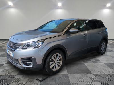 a silver car is parked on a checkered floor in a garage