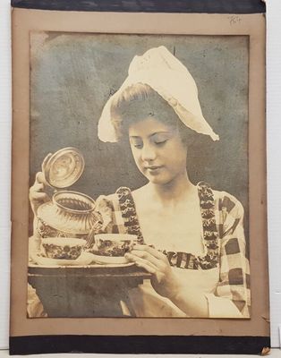 une vieille photo d'une femme tenant une assiette sur laquelle est posé un gâteau