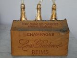 three bottles of champagne in a wooden crate on a table
