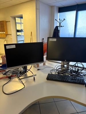 a desk with two computer monitors and a keyboard on it