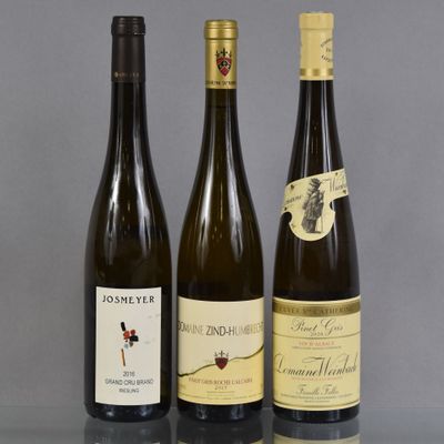 trois bouteilles de vin sont alignées sur une table