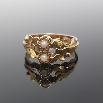 une image représentant une bague en or ornée de perles et de feuilles