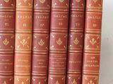 six red books lined up in a row on a white surface