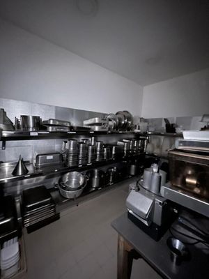 de nombreuses casseroles et poêles sur les étagères de la cuisine