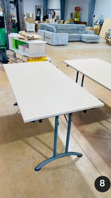 trois tables au milieu d'une pièce, avec des canapés en arrière-plan