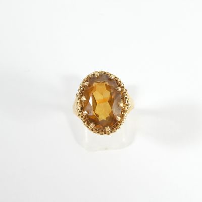 un gros plan d'une bague en or sertie d'une citrine facettée