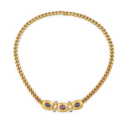 un collier en or avec trois pierres et une chaîne, sur fond blanc