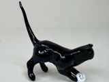 a black cat figurine on a white surface