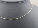 a gold chain necklace on a mannequin neck