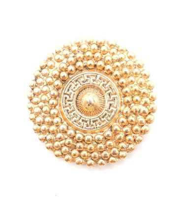 un gros plan d'une broche en or ornée de perles