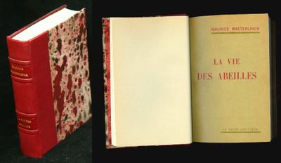 un livre ouvert posé sur une table, à côté d'un livre fermé