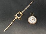 a gold clock and a silver watch on a black surface