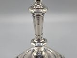 an antique silver plated candle holder on a grey background