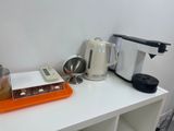 une cafetière et un mixeur posés sur une table blanche