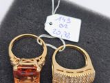 paire de boucles d'oreilles dorées ornées d'une pierre orange et de cristaux