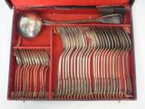 une boîte rouge contenant de l'argenterie sur une surface blanche