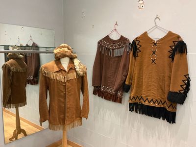 plusieurs vêtements traditionnels exposés dans une vitrine de musée