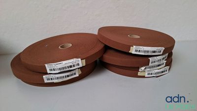 Deux rouleaux de tissu marron sont posés sur une table