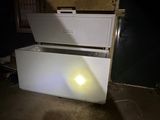 a white chest freezer sitting in the middle of a room