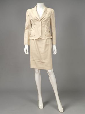 a woman ' s beige skirt suit and jacket on a mannequin mannequin mannequin mann