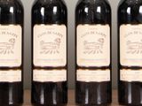 four bottles of wine are lined up on a table