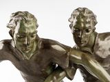 two bronze statues of a man and a woman holding hands
