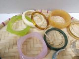 many different colored bracelets on a woven tray
