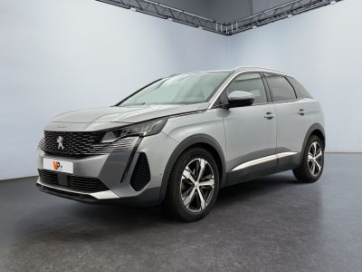 Une voiture argentée est garée dans une grande pièce aux murs blancs.