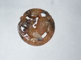 une photo d'une broche ornée d'un dragon