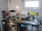 une cuisine équipée d'un évier, d'une cuisinière et d'un réfrigérateur