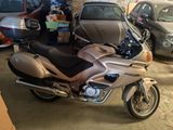 a silver motorcycle parked in a garage next to other cars