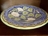 une assiette bleue et verte posée sur une table en bois