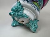 a vase with a bird on it sitting on a table