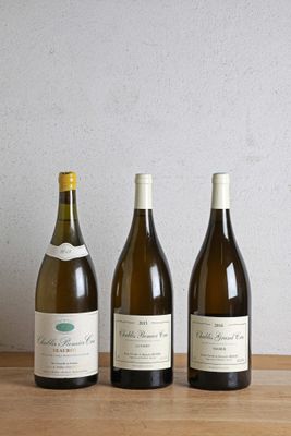 trois bouteilles de vin sont alignées sur une table en bois