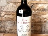 a bottle of wine sitting on a table in front of a brick wall