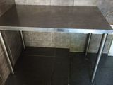 a stainless steel table in the corner of a bathroom