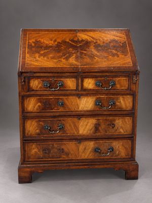 a walnut bureau on stand with three drawers