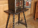 a small wooden table with a small antique camera on it