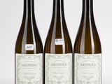 trois bouteilles de vin posées sur une table blanche
