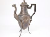 une théière en argent ornée d'un oiseau