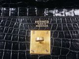 black crocodile skin purse with gold hardware and handle