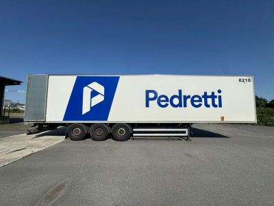 the semi truck is parked in the parking lot next to the building
