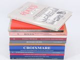 plusieurs livres empilés sur une surface blanche
