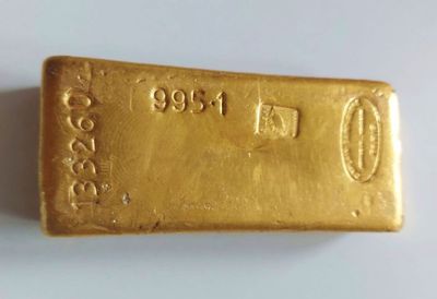a close up of a gold bar on a white surface
