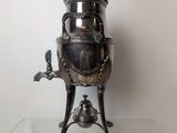 a silver tea pot sitting on a glass table