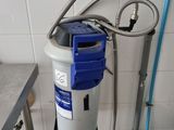 a blue and white water filterer in the corner of a kitchen